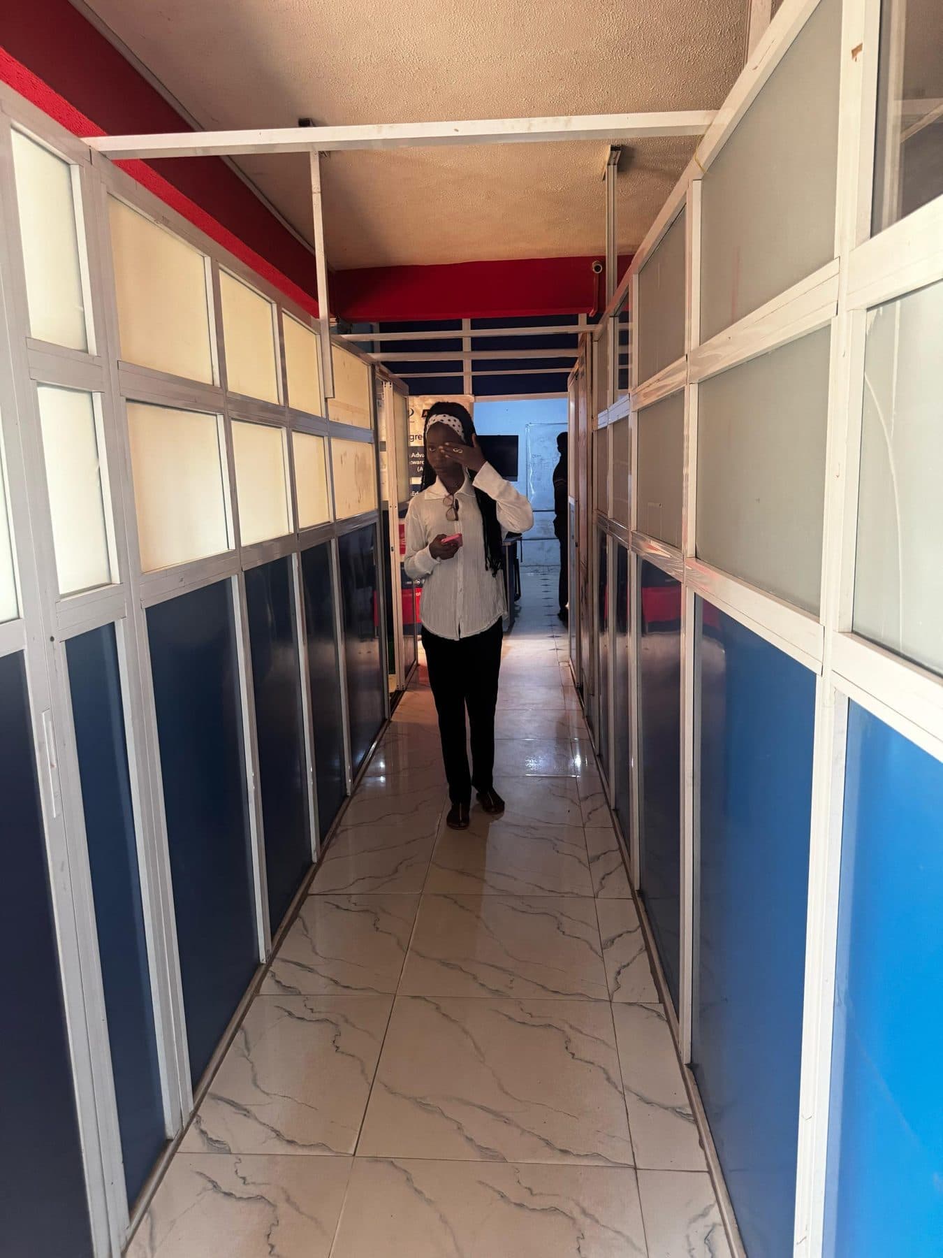 A student walking through a corridor on the APTECH Abeokuta campus